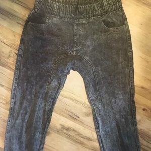 Faded jeans gather at the waste & at the ankles.